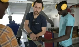Un casque jaune vissé sur les oreilles, Baptiste Lomenech, explique à une dizaine de jeunes entrepreneurs du Sénégal le fonctionnement de l'extrudeuse, une machine qui sert au recyclage du plastique ( AFP / SEYLLOU )