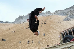Un Afghan exécute un salto à l'arrière d'un véhicule sur la montagne Reg-e-Rawan dans la région de Sayad, le 24 avril 2026, en Afghanistan