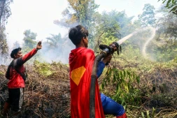 'adolescent indonésien Rudiansyah porte un costume de "Superman" en combattant un incendie, à Palangkaraya, dans le Kalimantan central, le 17 août 2026