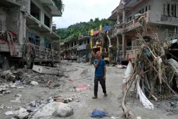 Un habitant passe devant des maisons endommagées par des crues soudaines à Devighat, dans le district de Nuwakot, le 31 août 2026 au Népal ( AFP / Arun SANKAR )