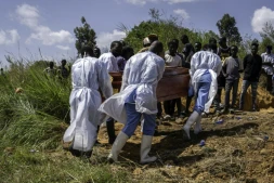 Des agents de santé, équipés de vêtements de protection, transportent vers le cimetière le cercueil d'une personnes suspectée d'avoir succombé à la maladie d'Ebola, à Bunia, dans l'est de la République démocratique du Congo, le 25 mai 2026