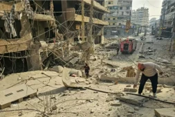 Des pompiers près d'un immeuble détruit sur le site de frappes aériennes israéliennes nocturnes dans la banlieue sud de Beyrouth, le 12 mars 2026 au Liban ( AFP / - )