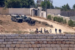 Des soldats israéliens au dessus de colons à Des soldats israéliens (en haut) montent la garde aux côtés de colons devant des maisons palestiniennes dans le village de Qusra, au sud de Naplouse, en Cisjordanie occupée, le 12 août 2026