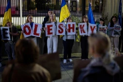 Des membres de la diaspora ukrainienne tiennent des pancartes formant le nom "Oleshky" (Olechky) devant l'ambassade américaine à Varsovie, le 6 octobre 2026