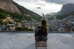Une touriste se fait filmer par un drone sur le toit d'une maison dans la favela de Rocinha, à Rio de Janeiro, au Brésil, le 5 mars 2026