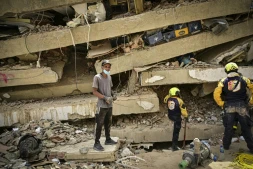 Raul Alvarado (g) cherche des proches disparus sous les décombres de l'immeuble OPP 26 de 16 étages ç Carabellada, dans l'Etat de La Guaira, le 6 juillet 2026 au Venezuela