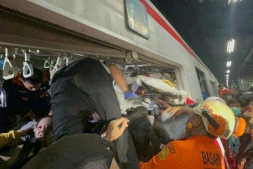 Des secouristes sur le site où une locomotive de train de voyageurs a percuté le wagon arrière d'un train de banlieue à la gare de Bekasi Timur, le 28 avril 2026 à Bekasi, en Indonésie