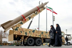 Des femmes passent devant un lanceur de missile balistique à Téhéran, le 11 février 2026, lors d'un rassemblement marquant le 47e anniversaire de la révolution islamique de 1979 en Iran