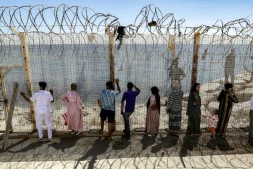 Des personnes attendent derrière une clôture surmontée de barbelés le retour de proches ayant tenté de franchir la frontière pour entrer dans l’enclave espagnole de Ceuta, le 2 août 2026 à Fnideq