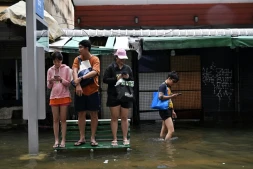 Des habitants sur un banc dans une rue de Bangkok, où l'état de catastrophe naturelle a été déclaré après des pluies diluviennes qui ont inondé habitations, commerces et axes de circulation, le 27 septembre 2026