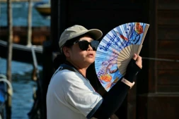 Une touriste utilise un éventail pour se rafraîchir, place Saint-Marc, à Venise, lors d'un épisode de canicule en Europe, le 26 juin 2026
