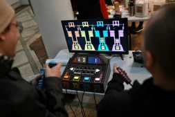 Des personnes jouent à un jeu vidéo fabriqué à partir de composants électroniques recyclés lors de la 3e Rencontre fédérale Cyberciruja à Buenos Aires, le 16 août 2025 en Argentine
