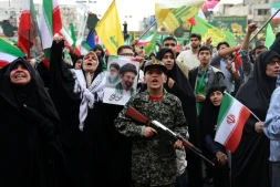 Un jeune Iranien en uniforme militaire brandit un fusil factice lors d'un rassemblement des partisans du pouvoir, le 29 avril 2029 à Téhéran