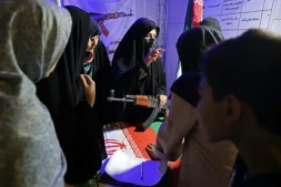 Des Iraniennes apprennent le maniement des armes dans un stand sur la place Hafter Tir de Téhéran, le 17 mai 2026
