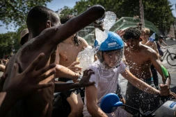Un groupe d'adolescents asperge d'eau un jeune homme circulant en scooter près du canal Saint-Martin, à Paris, le 24 juin 2026