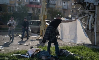 Un homme couvre d'un drap les corps de victimes de frappes russes à Kramatorsk, dans l'Est de l'Ukraine, le 5 mai 2026