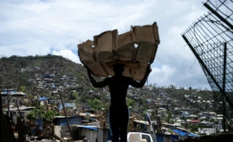Un homme transporte des matériaux pour reconstruire sa maison à Mamoudzou, à Mayotte, le 2 janvier 2025 ( AFP / JULIEN DE ROSA )