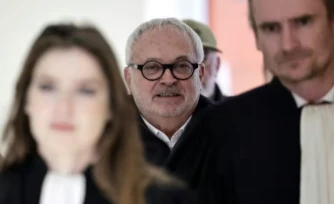 L'ancien sénateur Joël Guerriau (c) arrive au Palais de justice de Paris pour son procès, le 26 janvier 2026, accusé d'avoir drogué la députée Sandrine Josso pour la violer ( AFP / STEPHANE DE SAKUTIN )