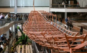 Des planches de bois anciennes provenant de la deuxième barque du roi Khéops installées sur une structure métallique au Grand Musée égyptien de Gizeh, en périphérie du Caire, le 23 décembre 2025 ( AFP / Ahmed HASAN )