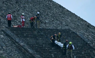 Des experts médico-légaux et des membres de la Croix-Rouge transportent un corps sur la pyramide de la Lune, sur le site archéologique de Teotihuacan, après une fusillade survenue à Teotihuacan, dans l'Etat de Mexico, le 20 avril 2026