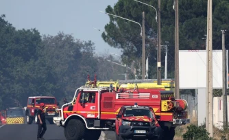 Des camions de pompiers sont stationnés devant un bâtiment où un incendie s’est déclaré et où deux pompiers ont trouvé la mort en combattant le feu, à Mérignac, non loin de l’aéroport de Bordeaux-Mérignac, le 21 juillet 2026. | AFP