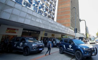 Des véhicules de police sont garés devant un bâtiment du centre financier de l'avenue Faria Lima à Sao Paulo, au Brésil, le 28 août 2025. La police brésilienne a lancé jeudi une vaste opération contre un vaste réseau de blanchiment d'argent impliquant le crime organisé et le secteur financier, ont annoncé les autorités. (Photo de Miguel SCHINCARIOL/AFP) - M. Schincariola/AFP
