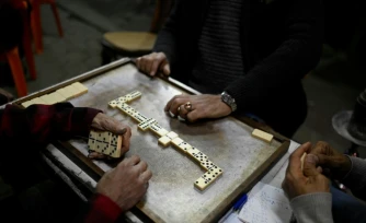 Des personnes jouent aux dominos à la terrasse d'un café avant la fermeture en application du couvre-feu, dans le centre-ville du Caire, le 2 avril 2026 en Egypte