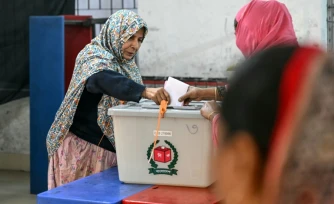 Une électrice (g) vote  à Dacca, lors des élections législatives au Bangladesh, le 12 février 2026