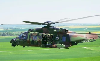 Le président français Emmanuel Macron (G) à bord d’un hélicoptère NH90 Caïman lors des manœuvres militaires Orion 2026 sur un camp à Suippes, dans l’est de la France, le 30 avril 2026