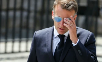 Le président Emmanuel Macron ajuste ses lunettes lors d'une cérémonie d'hommage au capitaine Alfred Dreyfus, à Paris, le 12 juillet 2026