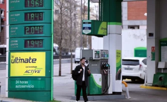 Un homme marche devant une station service à Madrid le 20 mars 2026