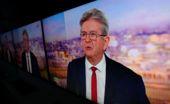 L'image du leader de LFI Jean-Luc Mélenchon affichée sur des écrans alors qu'il officialise sa candidature pour la présidentielle de 2027 sur le plateau de TF1, le 3 mai 2026