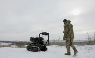 Un militaire ukrainien de la 30e brigade mécanisée indépendante prépare un véhicule terrestre robotisé sans pilote armé d'un lance-grenades Mk 19 pour un test dans un lieu non divulgué de la région de Donetsk le 27 janvier 2026.