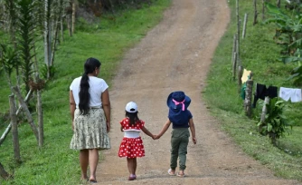 Francia Giraldo, une femme autochtone embera chami et dirigeante communautaire, marche avec ses petites-filles dans une réserve de Pueblo Rico, en Colombie, le 9 avril 2026
