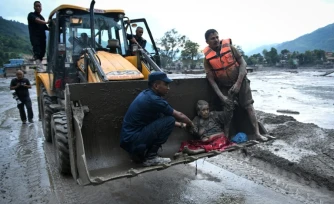 Les secouristes évacuent une personne ayant survécu à la crue soudaine à Devghat, dans le district de Nuwakot au Népal, le 26 août 2026