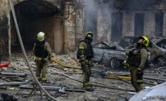 Des pompiers ukrainiens éteignent un incendie dans des bùtiments touchés par des frappes aériennes russes dans la ville portuaire d'Odessa, le 9 août 2026