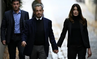 Nicolas Sarkozy (C) et son épouse Carla Bruni-Sarkozy, le jour de son incarcération à la prison de la Santé, le 21 octobre 2025 à Paris