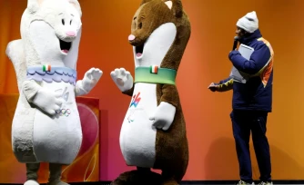 Les hermines Milo (d) et Tina, mascottes des Jeux olympiques de Milan-Cortina, à Cortina d’Ampezzo avant le dernier relais de la flamme olympique dans la ville, le 26 janvier 2026