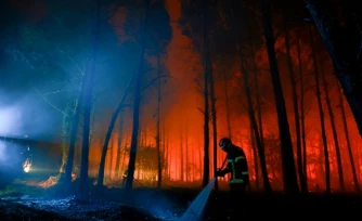 Un pompier lutte contre un feu de forêr à Luglon, dans les Landes, le 14 août 2026