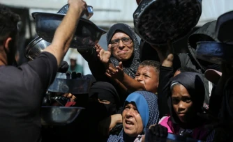 Nihaya Al-Masri (C), une Palestinienne déplacée lors d'une distribution alimentaire à Khan Younès, dans le sud du territoire palestinien, le 6 octobre 2026 
