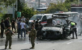 Des secouristes autour d'un véhicule ciblé par une frappe de drone israélien sur une autoroute près de la ville de Jiyeh, au sud de Beyrouth, le 13 mai 2026 au Liban