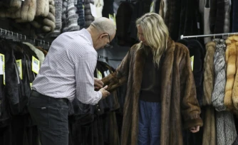 Le propriétaire du magasin de fourrures Madison Avenue Furs à New York, Larry Cowit, avec une cliente, le 10 mars 2026