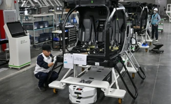 Des employés travaillent sur une chaîne de montage pour la voiture volante électrique "Land Aircraft Carrier" dans une usine de la filiale Aridge de Xpeng à Guangzhou, dans le sud de la Chine, le 6 novembre 2025