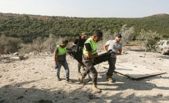 Les premiers secours évacuent un corps des décombres à la suite d'une frappe aérienne israélienne qui a visé une maison dans le village d'Ansar, dans le sud du Liban, le 15 août 2026.