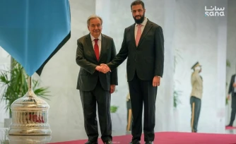 Photo fournie par l'agence de presse syrienne Sana le 25 juillet 2026 montrant le secrétaire général de l'ONU, Antonio Guterres (G) serrant la main du président syrien Ahmad al-Chareh (D) au palais présidentiel à Damas