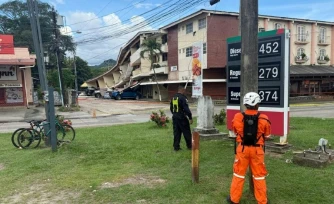 Un policier panaméen et un secouriste montent la garde à côté d'un immeuble effondré après un séisme, à Penonomé, au Panama, le 9 octobre 2026