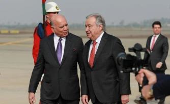 Le ministre des Affaires étrangÚres irakien Fuad Hussein (à gauche) marche aux cÎtés du secrétaire général des Nations unies (ONU) Antonio Guterres à l'arrivée de ce dernier à Bagdad le 13 décembre 2025.