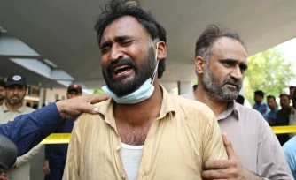 Un père pleure après la mort de son enfant à la suite d'un incendie devant le service de santé maternelle et infantile de l'hôpital PIMS, à Islamabad, le 26 août 2026. L'incendie a coûté la vie à 14 nourrissons.