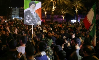 Un portrait du guide suprême iranien Ali Khamenei, tué au premier jour de la guerre, est brandi au cours des funérailles de membres d'une milice irakienne pro-Téhéran à Bagdad, le 17 mars 2026