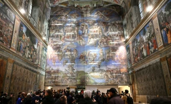 Des journalistes lors d'une visite de la chapelle Sixtine, où la célèbre fresque du Jugement dernier de Michel-Ange a connu sa plus importante restauration depuis plus de trente ans, le 28 février 2026 au Vatican